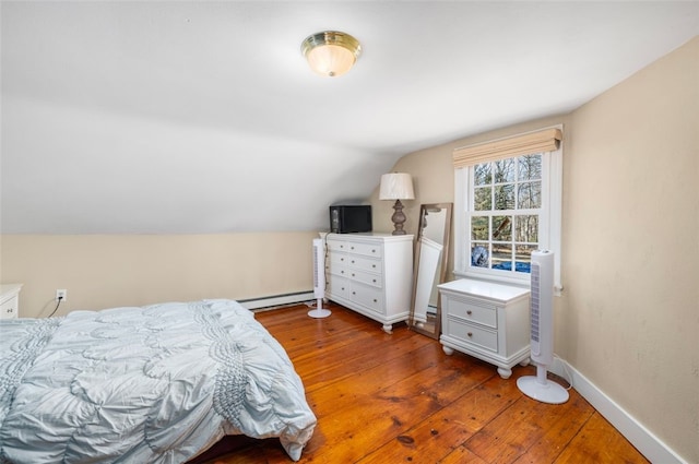 bedroom with baseboard heating, wood-type flooring, lofted ceiling, and baseboards