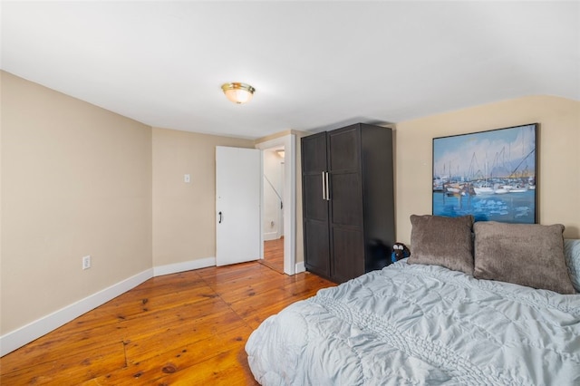 bedroom with hardwood / wood-style flooring and baseboards