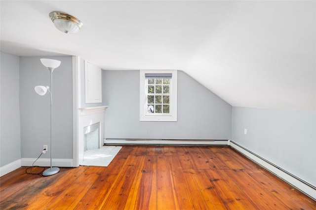 bonus room featuring a baseboard radiator, wood-type flooring, vaulted ceiling, and baseboards