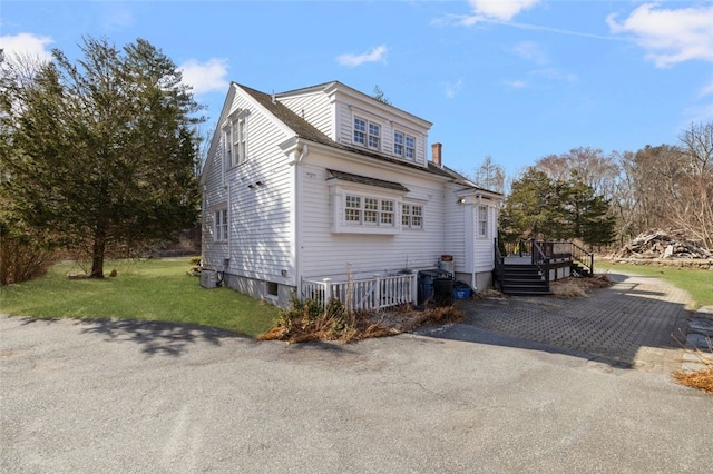 view of side of property with a deck and a lawn