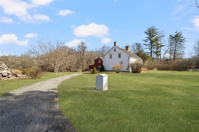 view of home's exterior with a chimney and a lawn