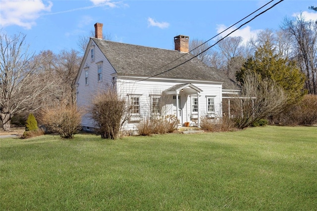 view of front of home with a chimney, a front lawn, and a shingled roof