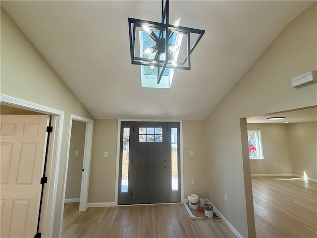 entryway with lofted ceiling, light wood-style flooring, and baseboards