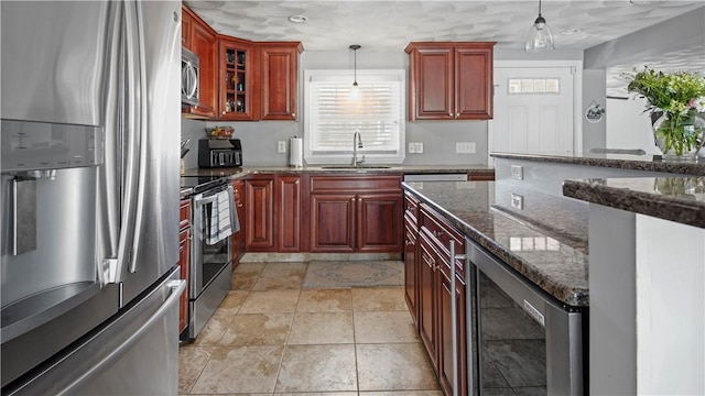 kitchen with beverage cooler, reddish brown cabinets, stainless steel appliances, and a sink