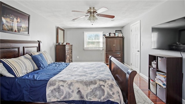 bedroom featuring baseboards, ceiling fan, and dark wood-style flooring