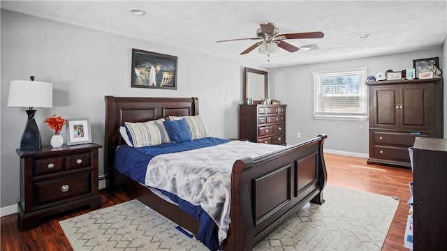 bedroom featuring wood finished floors, visible vents, baseboards, recessed lighting, and baseboard heating