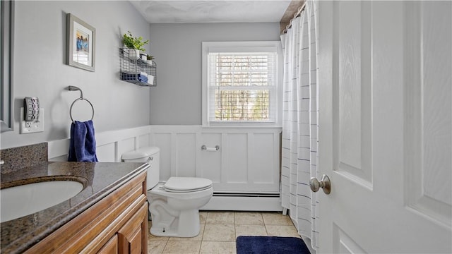 bathroom with tile patterned flooring, a baseboard heating unit, toilet, wainscoting, and vanity