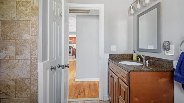 bathroom featuring visible vents, vanity, and wood finished floors