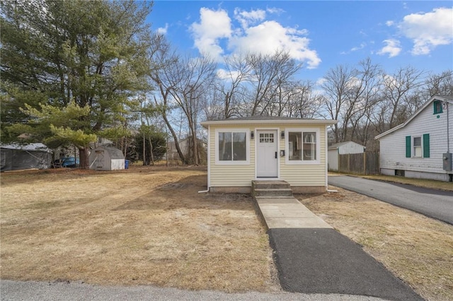 bungalow-style house with an outbuilding and fence