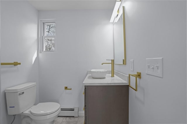 half bathroom featuring vanity, toilet, marble finish floor, and baseboard heating