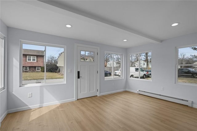 entryway with a healthy amount of sunlight, wood finished floors, and a baseboard radiator