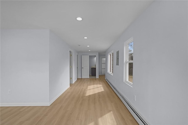 hallway featuring recessed lighting, a baseboard radiator, baseboards, and light wood-style flooring