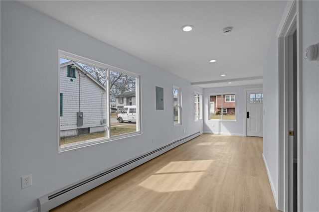 corridor featuring baseboards, electric panel, recessed lighting, a baseboard heating unit, and light wood-type flooring