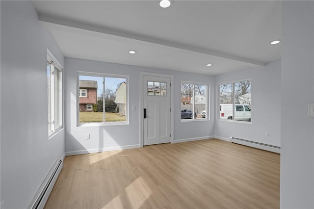 foyer entrance featuring baseboards, light wood-type flooring, and baseboard heating