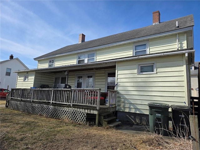 back of house featuring a chimney