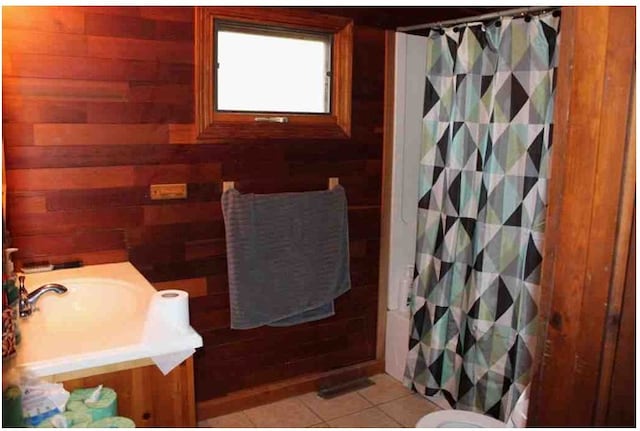 bathroom featuring tile patterned floors, wood walls, vanity, and a shower with curtain