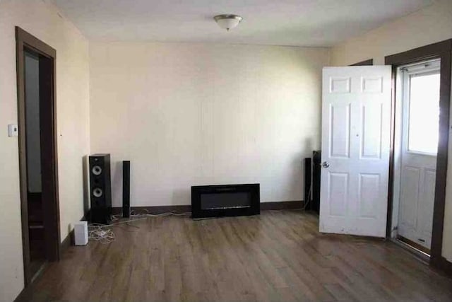 spare room featuring baseboards and wood finished floors