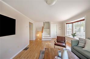 living room featuring stairs, visible vents, baseboards, and light wood finished floors