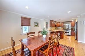 dining space featuring crown molding, light wood-style flooring, a healthy amount of sunlight, and baseboards