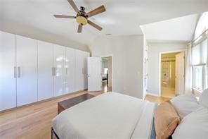 bedroom featuring a ceiling fan, vaulted ceiling, and light wood-style floors