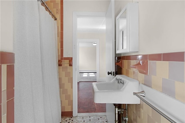 bathroom featuring tile patterned floors, tile walls, and a sink