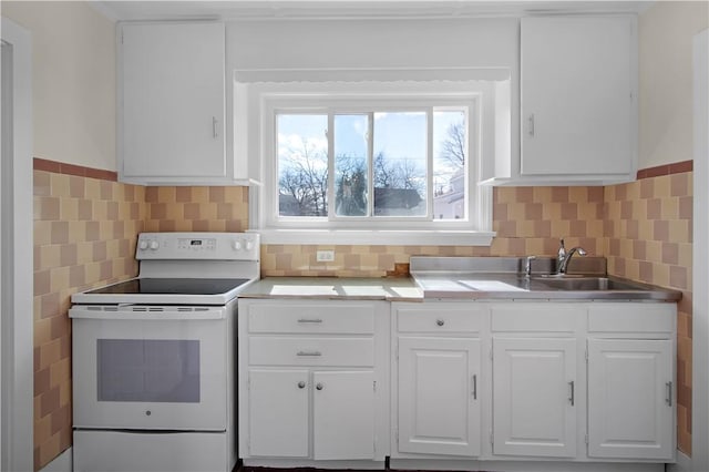 kitchen featuring white range with electric stovetop, white cabinets, light countertops, and a sink