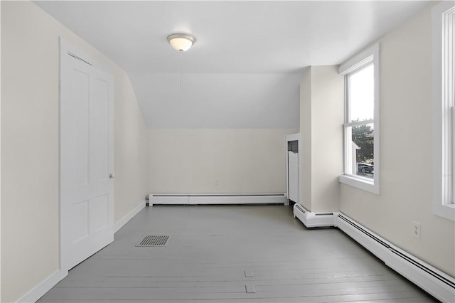 bonus room with a baseboard heating unit, baseboards, vaulted ceiling, baseboard heating, and wood-type flooring