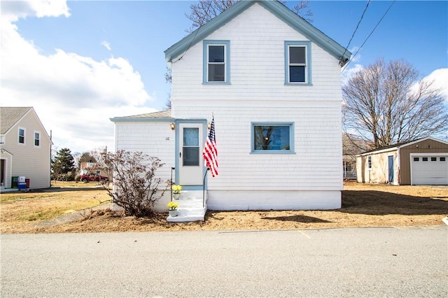 traditional-style house featuring an outbuilding, entry steps, and a garage