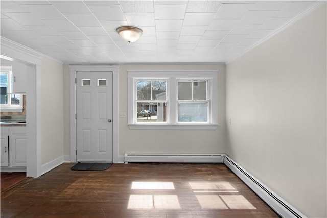 entrance foyer featuring dark wood-style flooring, crown molding, baseboards, and a baseboard radiator