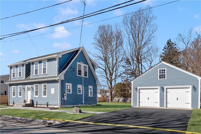 view of home's exterior featuring fence, a yard, an outdoor structure, a garage, and aphalt driveway