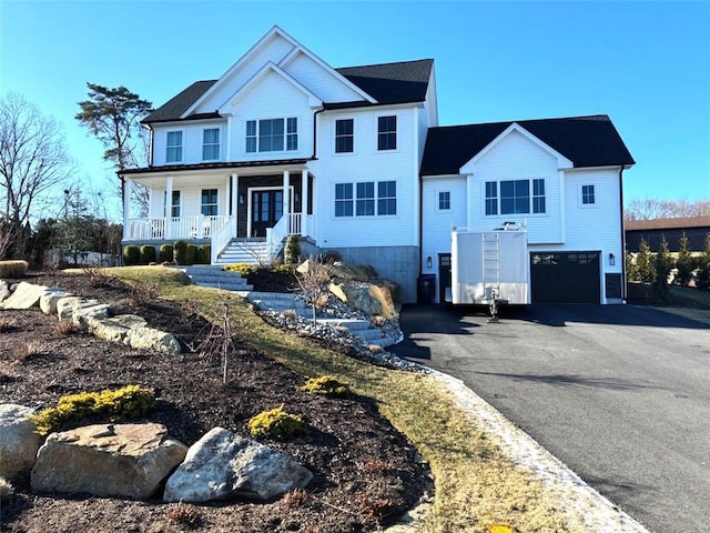 view of front facade featuring a porch, a garage, and driveway