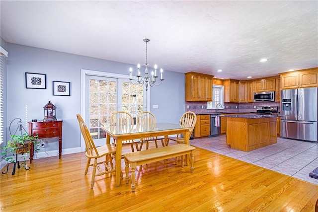 dining space with light wood-style flooring, recessed lighting, baseboards, and a chandelier