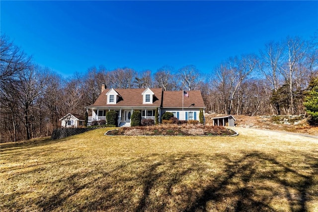 cape cod house with a front lawn and covered porch