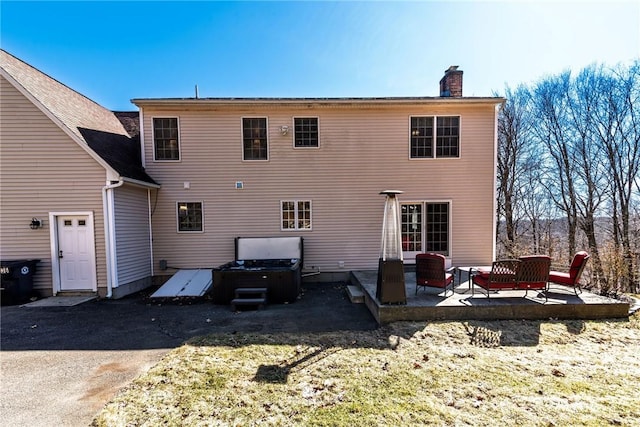 back of house with a chimney and a patio