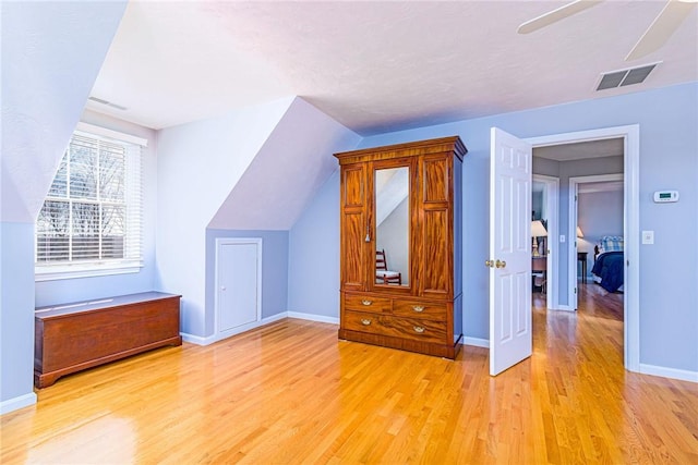 bonus room featuring visible vents, baseboards, lofted ceiling, and light wood-style flooring