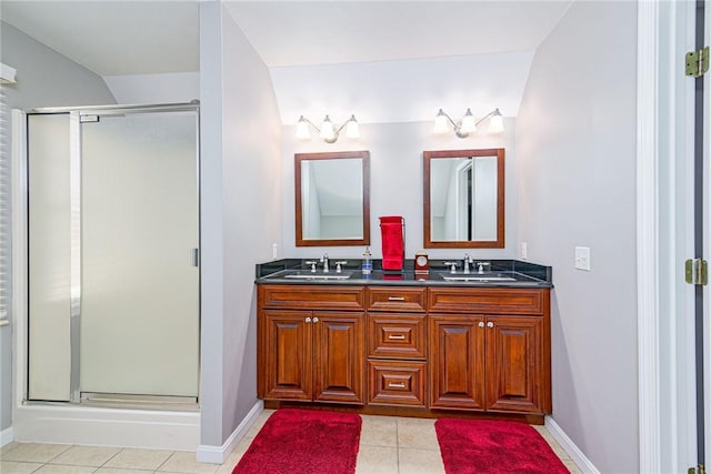 bathroom with tile patterned flooring, a shower stall, double vanity, and a sink