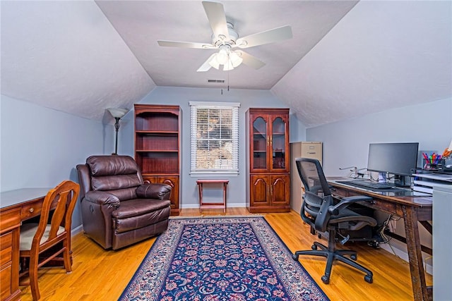 office space with vaulted ceiling, visible vents, ceiling fan, and wood finished floors