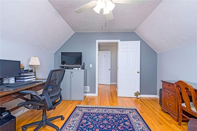 office featuring lofted ceiling, wood finished floors, and a textured ceiling