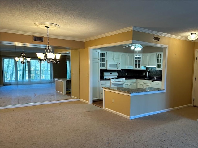 kitchen with visible vents, glass insert cabinets, white cabinets, white appliances, and a sink