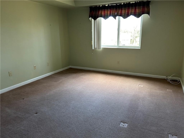 empty room featuring carpet flooring and baseboards