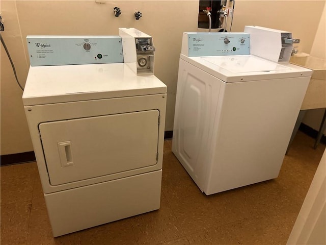 laundry room with a sink, tile patterned floors, and washer and clothes dryer