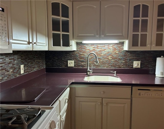 kitchen with a sink, glass insert cabinets, white appliances, white cabinets, and decorative backsplash