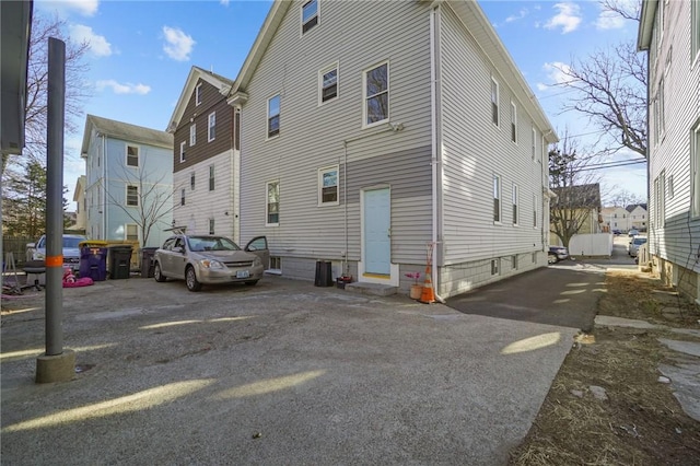 rear view of property with entry steps and driveway