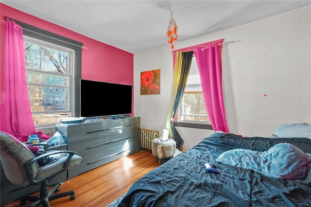 bedroom featuring radiator and wood finished floors