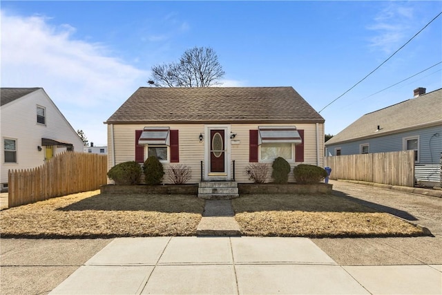 bungalow with fence and roof with shingles