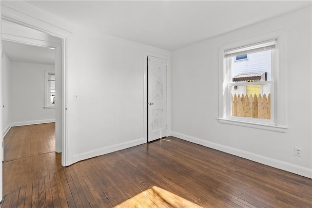 unfurnished bedroom featuring multiple windows and dark wood-type flooring