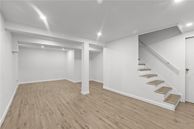 finished below grade area with stairway, recessed lighting, wood finished floors, and baseboards