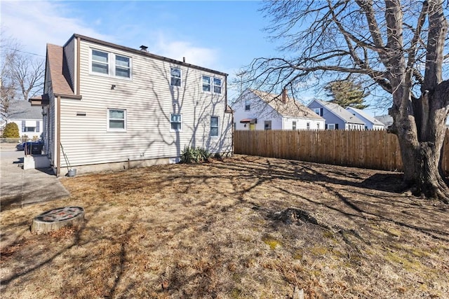 rear view of house featuring roof with shingles and fence