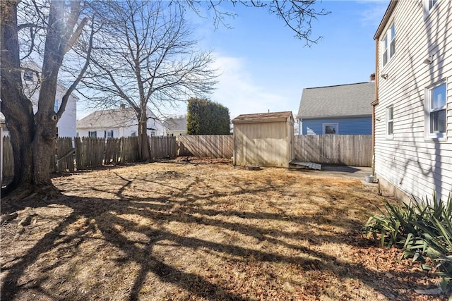 view of yard featuring an outbuilding, a storage unit, and a fenced backyard