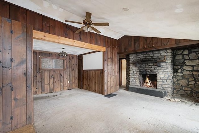 unfurnished living room featuring a ceiling fan, carpet floors, wooden walls, a brick fireplace, and vaulted ceiling